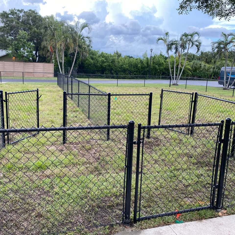 Black chain link fence with double swing gates around a backyard play area — Lobo Fences LLC, Southwest Florida
