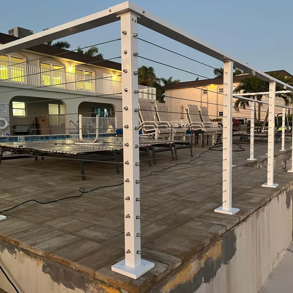 Cable railing system with white posts around a pool deck — Lobo Fences LLC, Southwest Florida