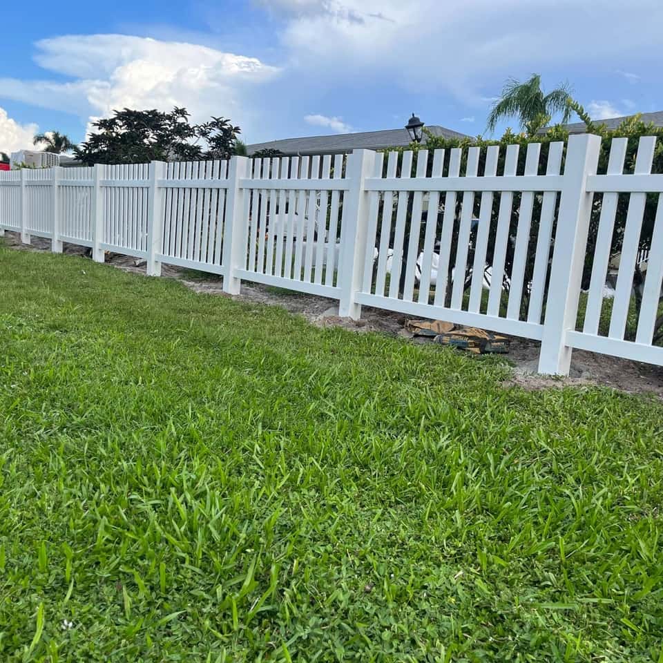 White vinyl picket fence bordering a green lawn — Lobo Fences LLC, Southwest Florida
