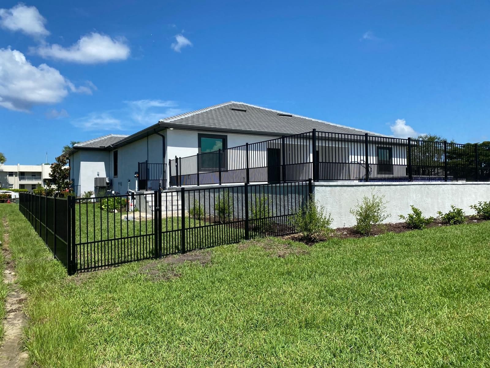 Black aluminum fence installed around a Fort Myers home by Lobo Fences LLC